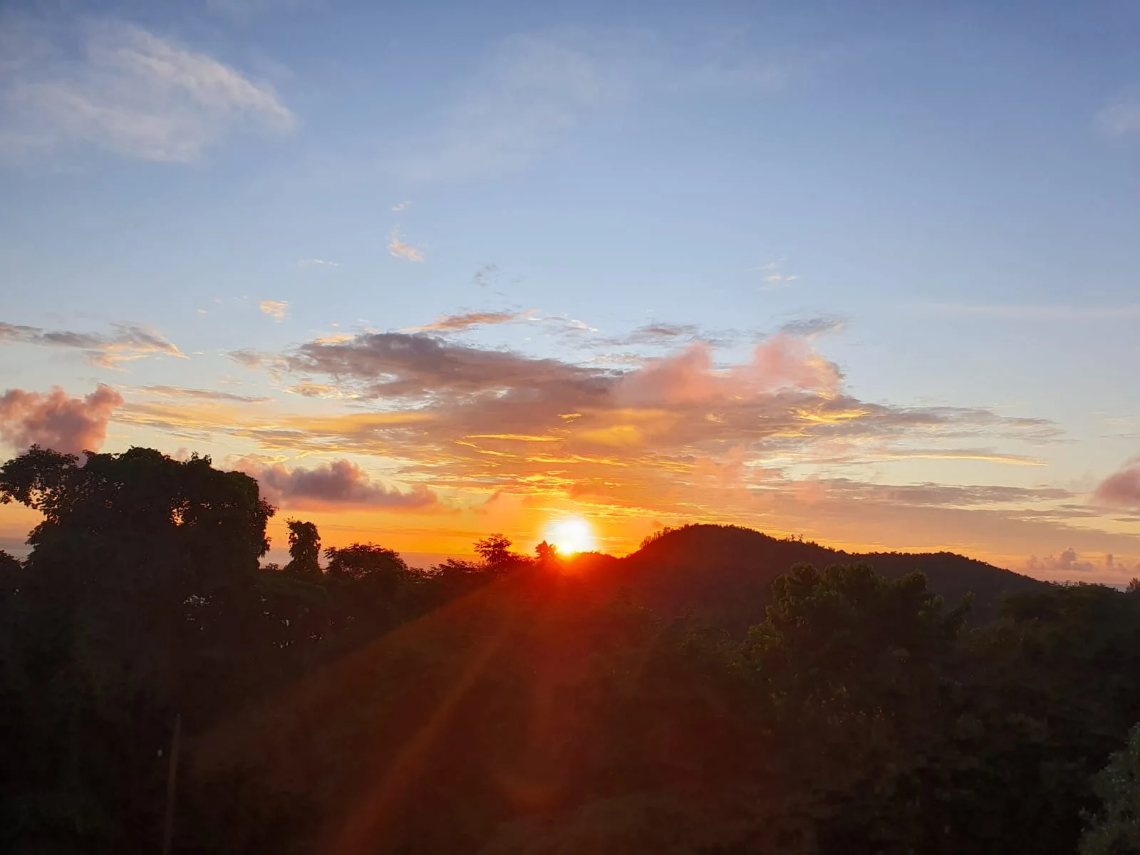 Golden sunset over lush tropical hills in south Mahé — view from the Baie Lazare area at Maison Soleil, Anse Soleil, Seychelles